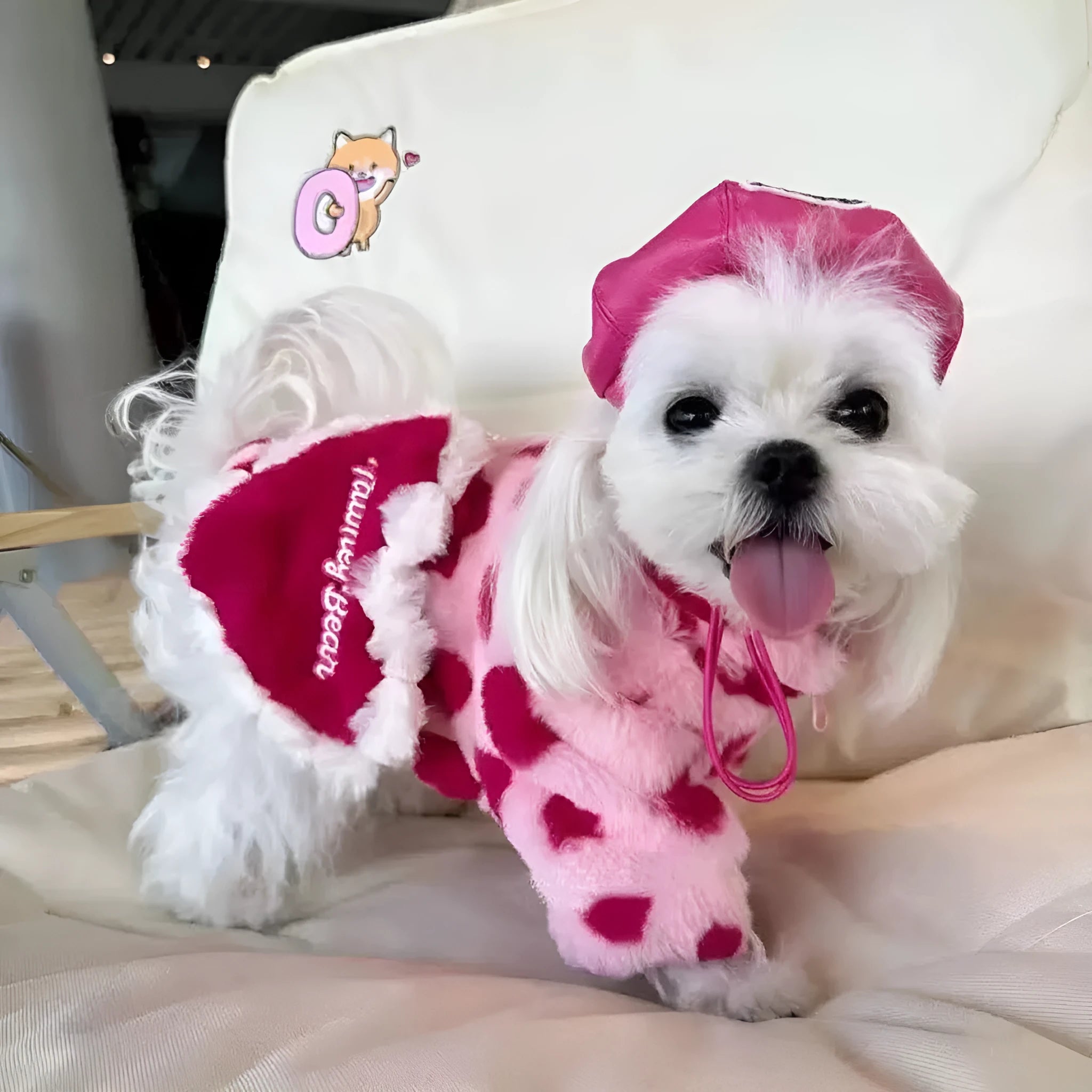 Small pink plush dog coat on a mannequin, showing British-style design for breeds like Teddy or Pomeranian.