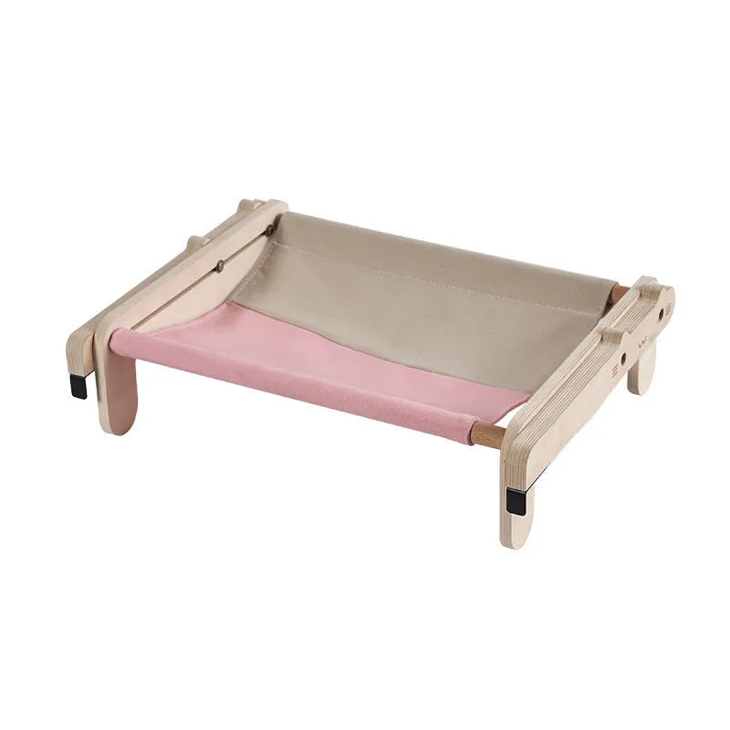 Solid wood cat bed with a removable patterned cover on a wooden floor