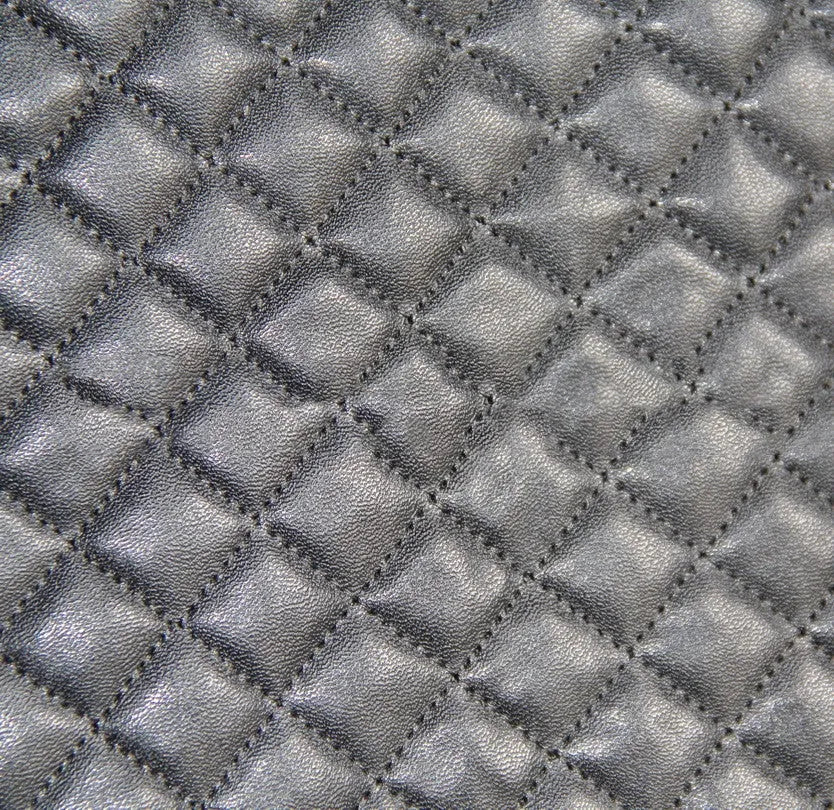 Black quilted automotive seat cover showing dimensional stitching pattern and plastic installation hooks