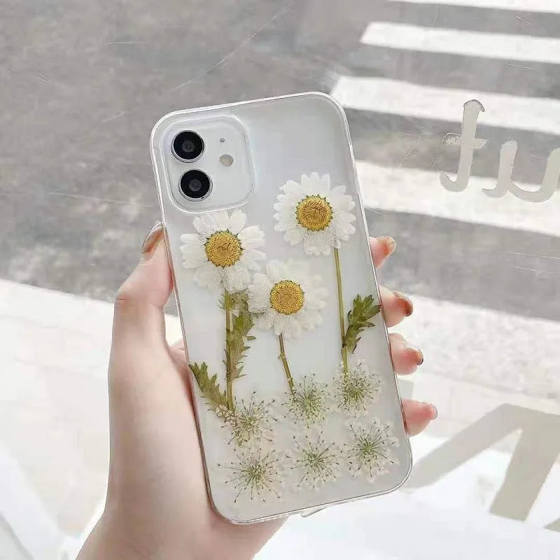 White TPU iPhone case with epoxy daisy floral design on back, shown fitted to a phone