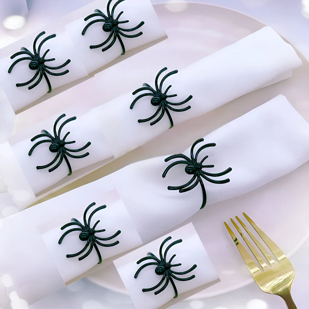 Set of six black metal spider-shaped napkin rings for Halloween table decorations.