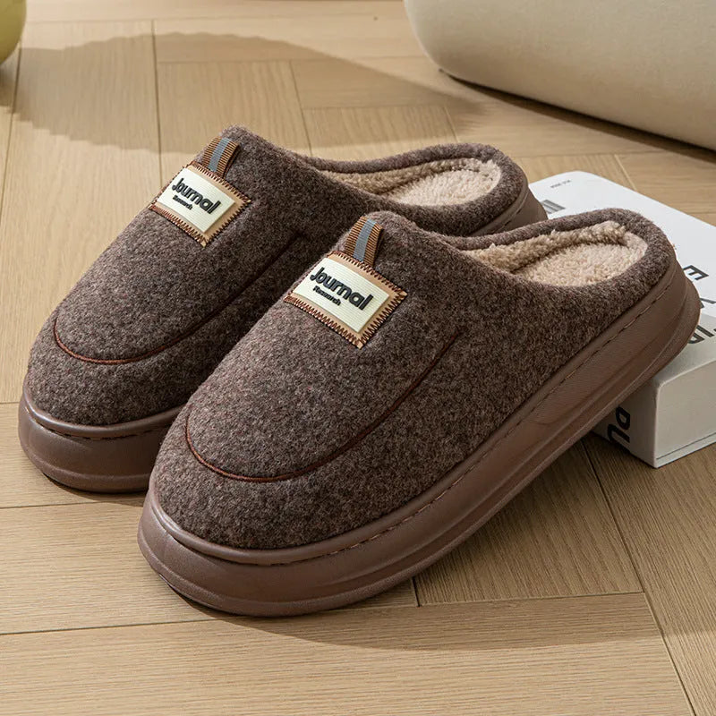 Men's brown suede slippers with a thickened sole on a wooden floor