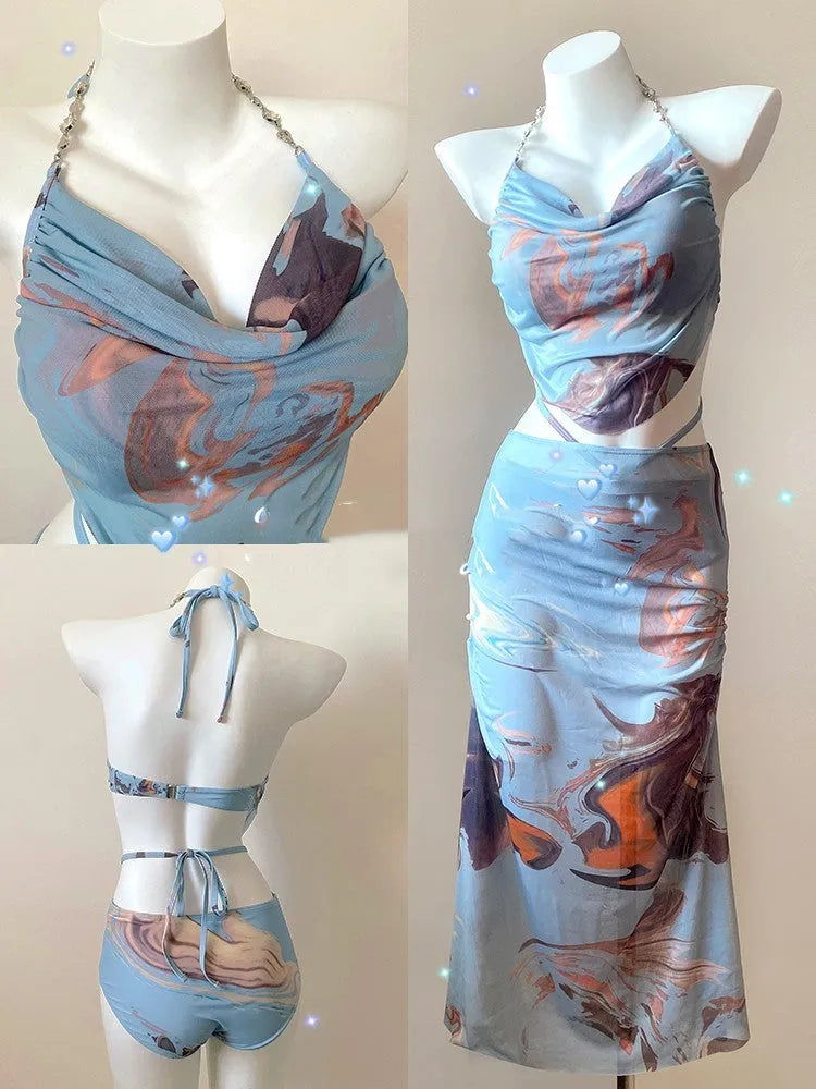 Women's blue printed bikini set with steel support top, pants, and matching skirt laid flat.