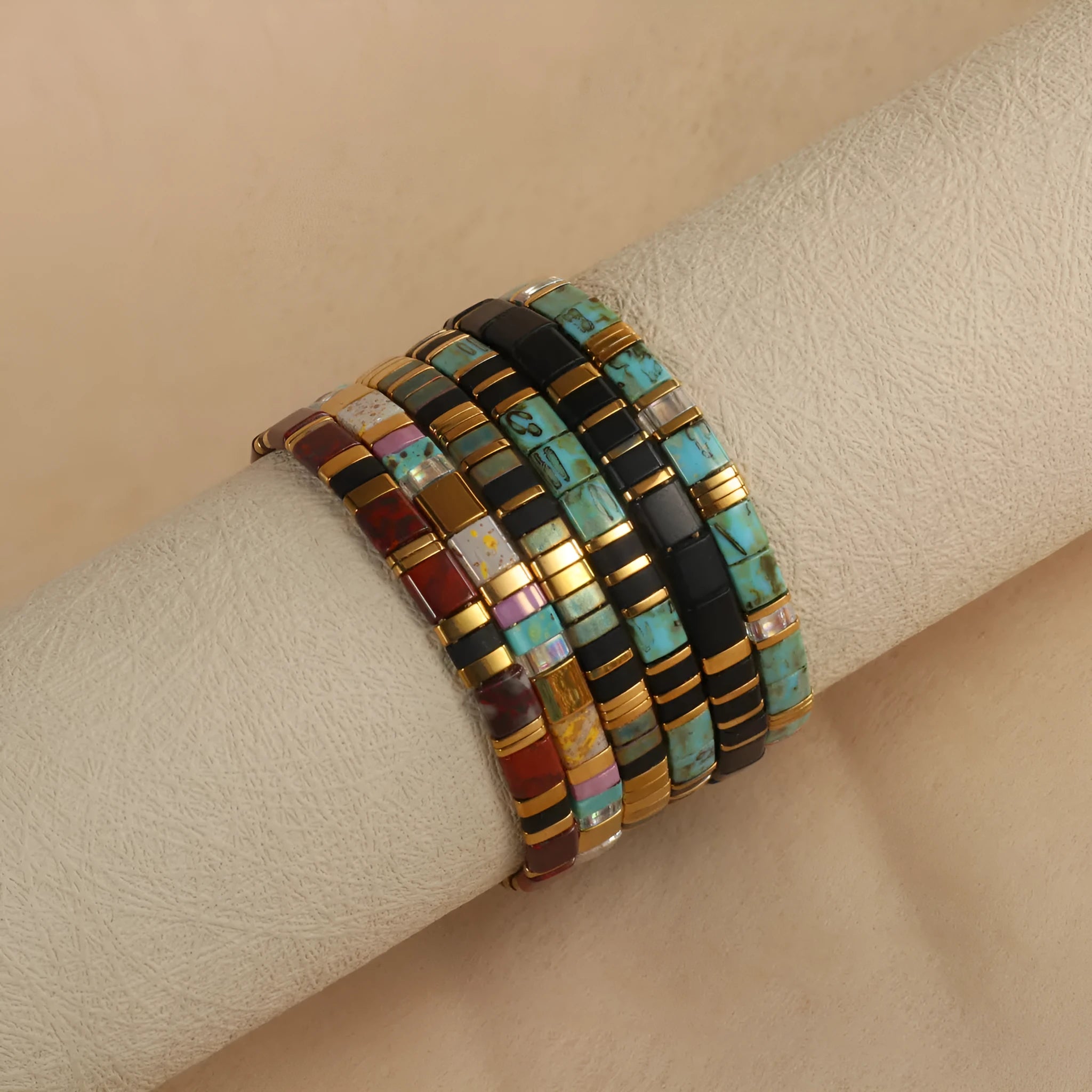 Geometric glass beaded bracelet in milky white, black, green, blue, or red on a plain background.