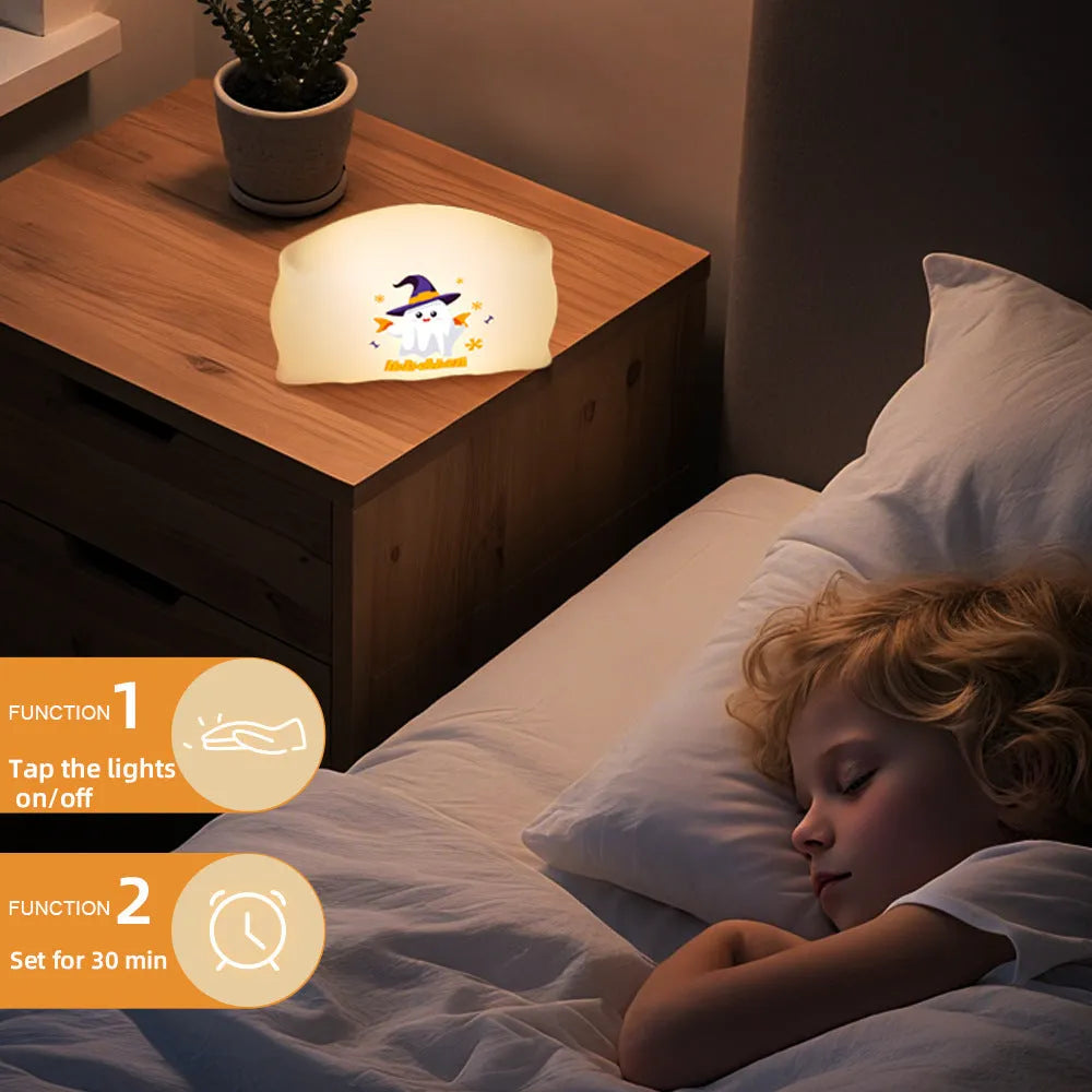Cartoon Halloween ghost doll table lamp with warm LED light on a bedside table.