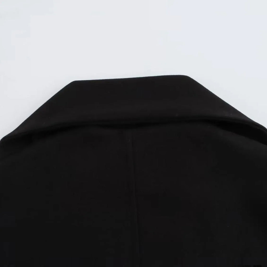 Woman wearing a long black overcoat with a detachable artificial fur collar, styled in a street-fashion look.