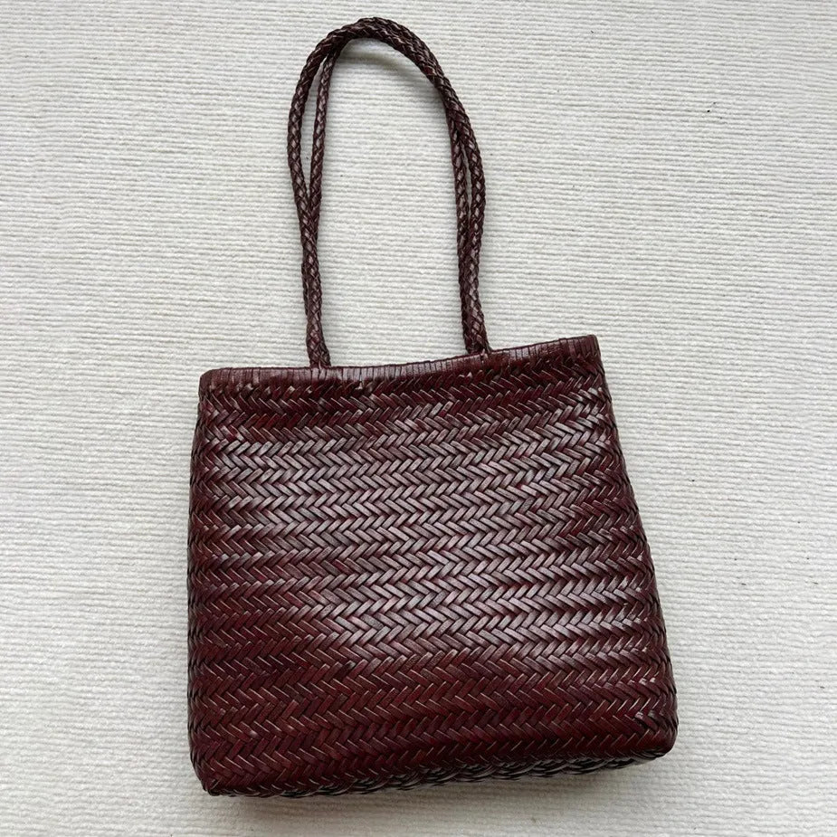 Brown handmade woven leather tote bag with a front pocket and polyester lining.