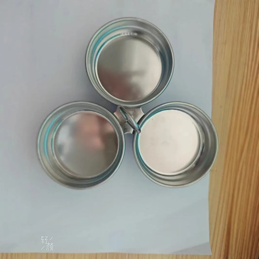 Mini stainless steel egg steamer shown in heart-shaped and round designs on a kitchen counter.
