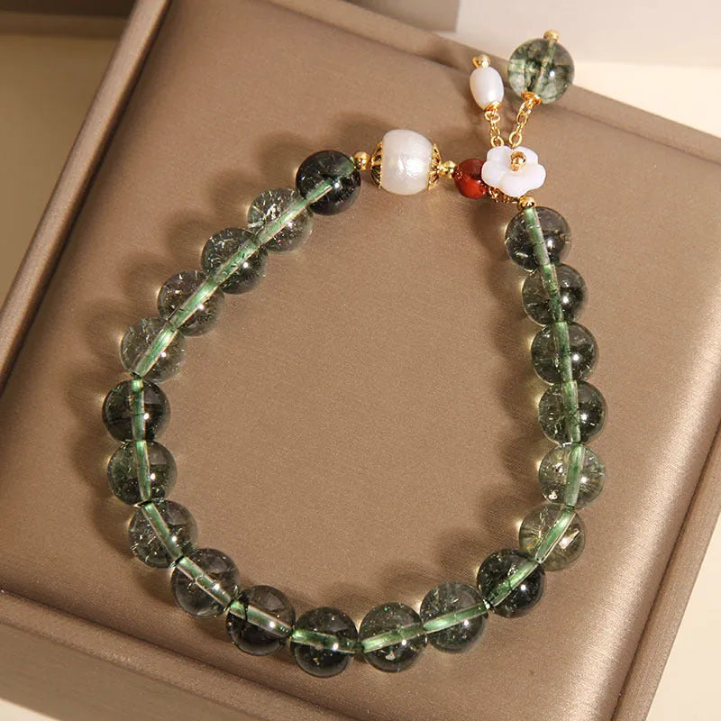 Green phantom quartz crystal bracelet with shell flower charms on wrist