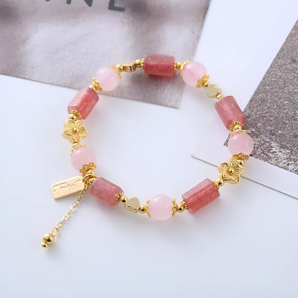 Pink strawberry crystal bracelet with star-shaped beads and a small heart charm on a white background
