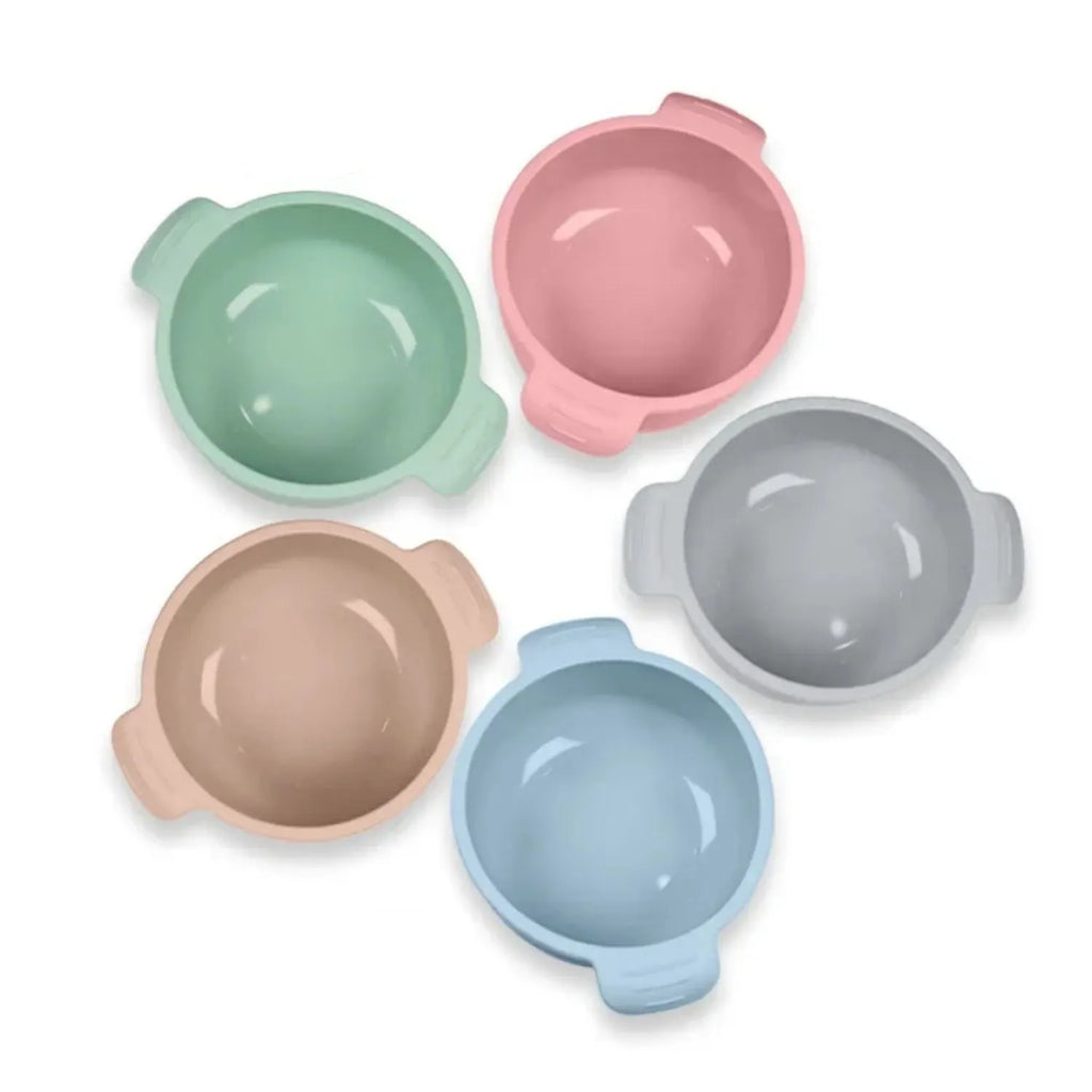 Blue silicone pet bowl with a white suction cup base on a kitchen floor.