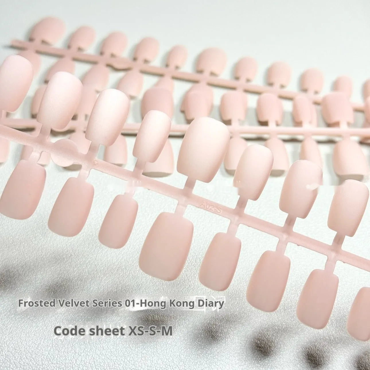 Set of frosted velvet false nails with Cat's Eye effect in short ladder sizes XS, S, and M.
