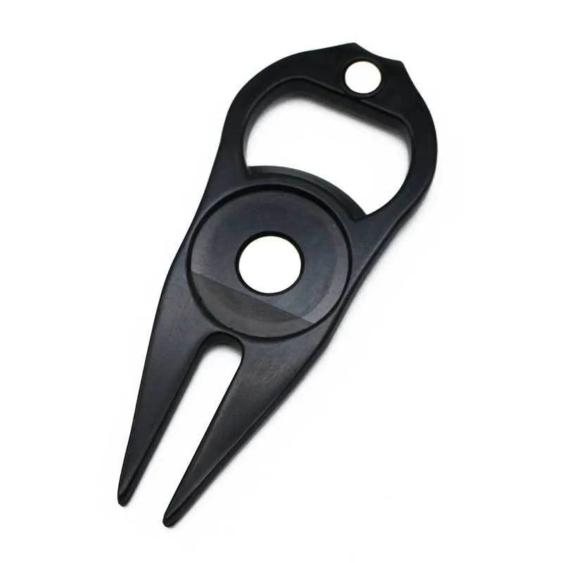Black zinc alloy golf ball yoke bottle opener tool on a putting green.