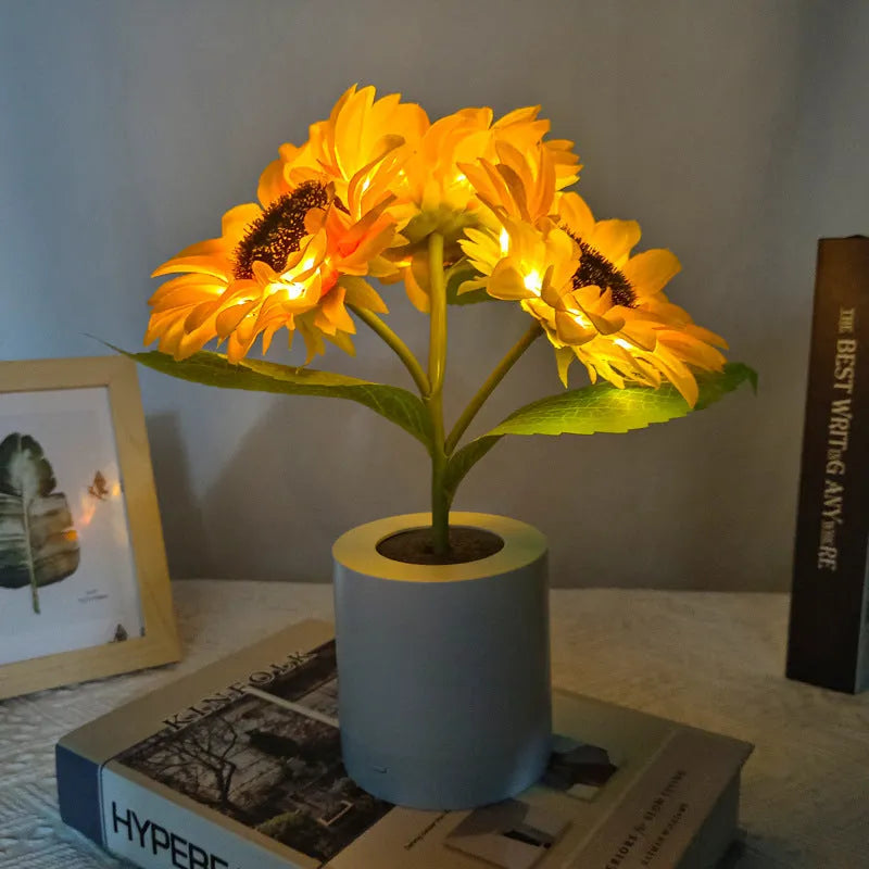 Rechargeable artificial sunflower LED night light on a table with USB cable.