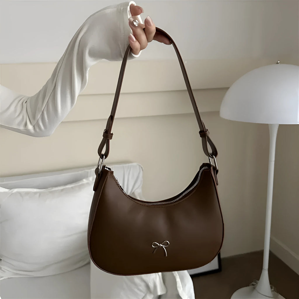 Small dumpling-shaped PU leather women's shoulder bag in khaki with a single strap and zip closure.