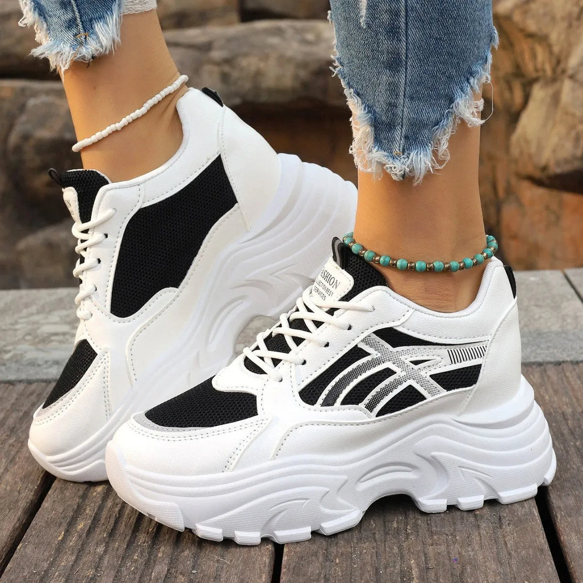 Women's platform wedge sneakers in black or white with mesh lining, rubber sole, front lace-up, round toe, and sewing thread detail.
