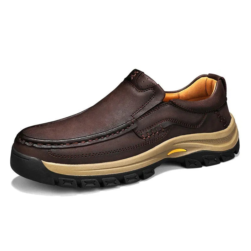 Men's black leather shoes with thick rubber soles and round toe design showing visible sewing thread construction