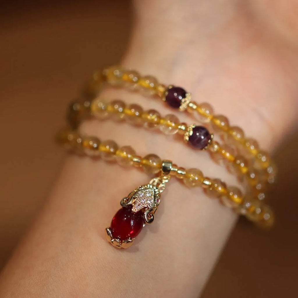 Handmade natural gold rutilated quartz bracelet in Chinese three-ring style with hanging chopsticks.