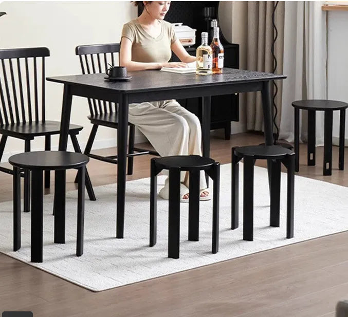 A stackable round metal dining stool in a modern style, shown in a choice of colours.