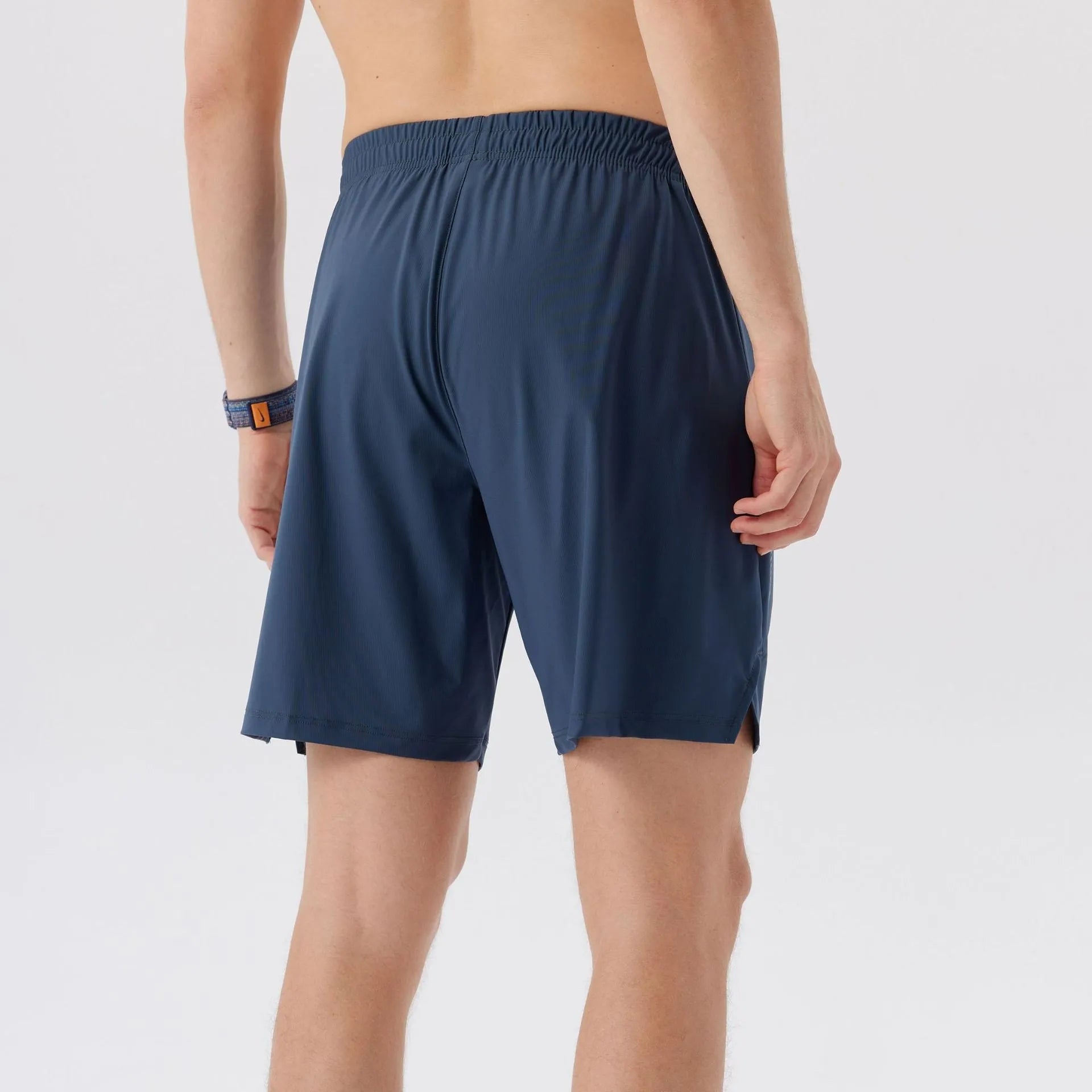 Man wearing black ice silk nylon sports shorts with mid waist and short length design