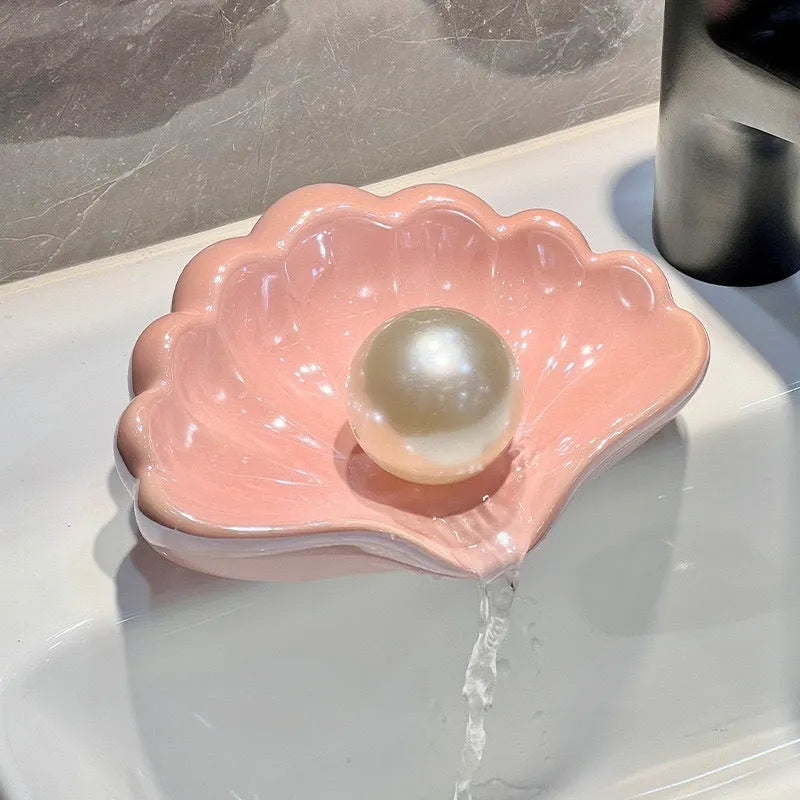 White plastic shell-shaped soap dish with drainage holes on a bathroom countertop