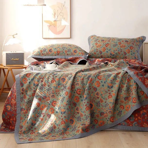 Cotton gauze floral blanket and two matching pillowcases laid out on a bed.