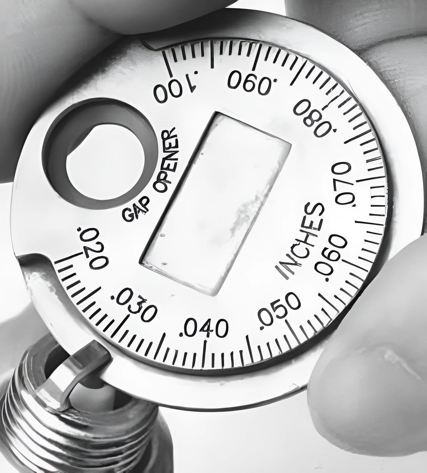 Round zinc alloy spark plug gauge with dual scales on a white background
