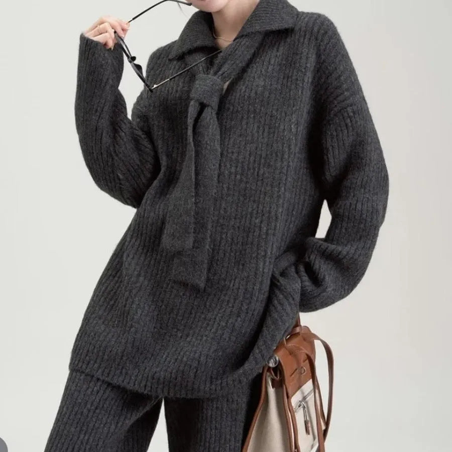 Woman wearing a beige acrylic knit sweater top and matching trousers from a casual two-piece set.