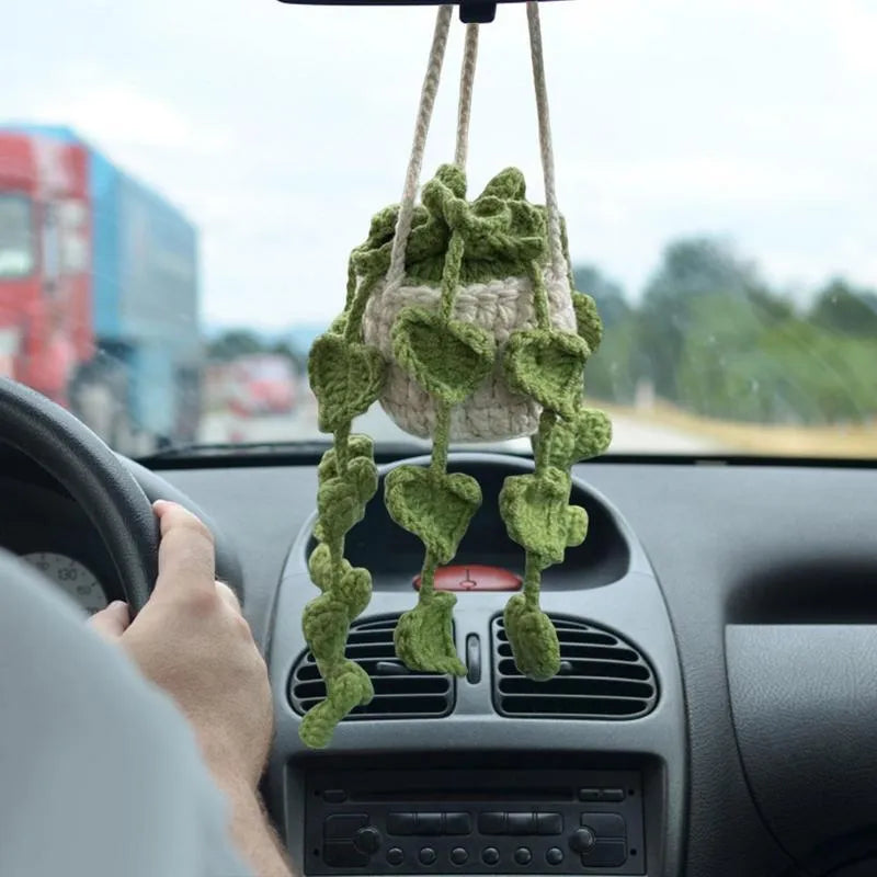 Green and white knitted wool car plant decoration with 25cm hanging rope on a car dashboard