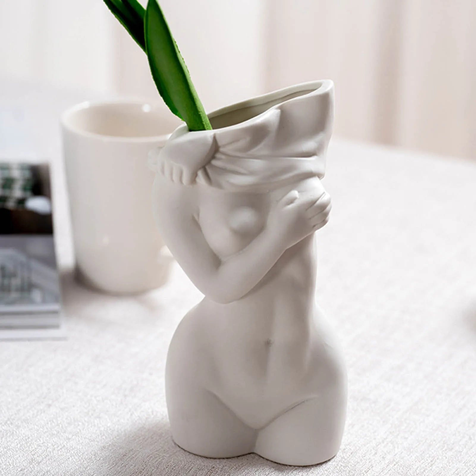 White porcelain figurative human vase with 21.2cm height on a shelf