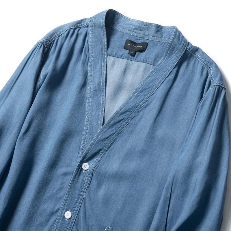 Men's dark blue V-neck denim coat with three-quarter sleeves showing loose fit and pocket detail