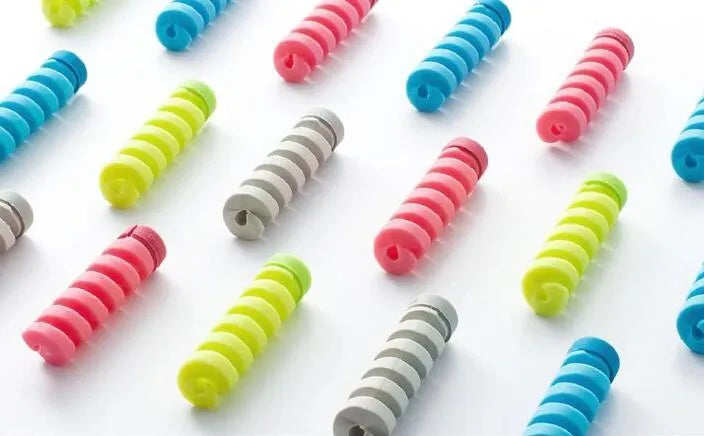 Plastic spiral charging cable protector in various colours next to a USB cable.