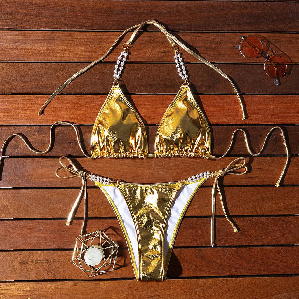 Gold bronzing effect women's halter neck bikini with lace-up back and pearl chain detail on mannequin