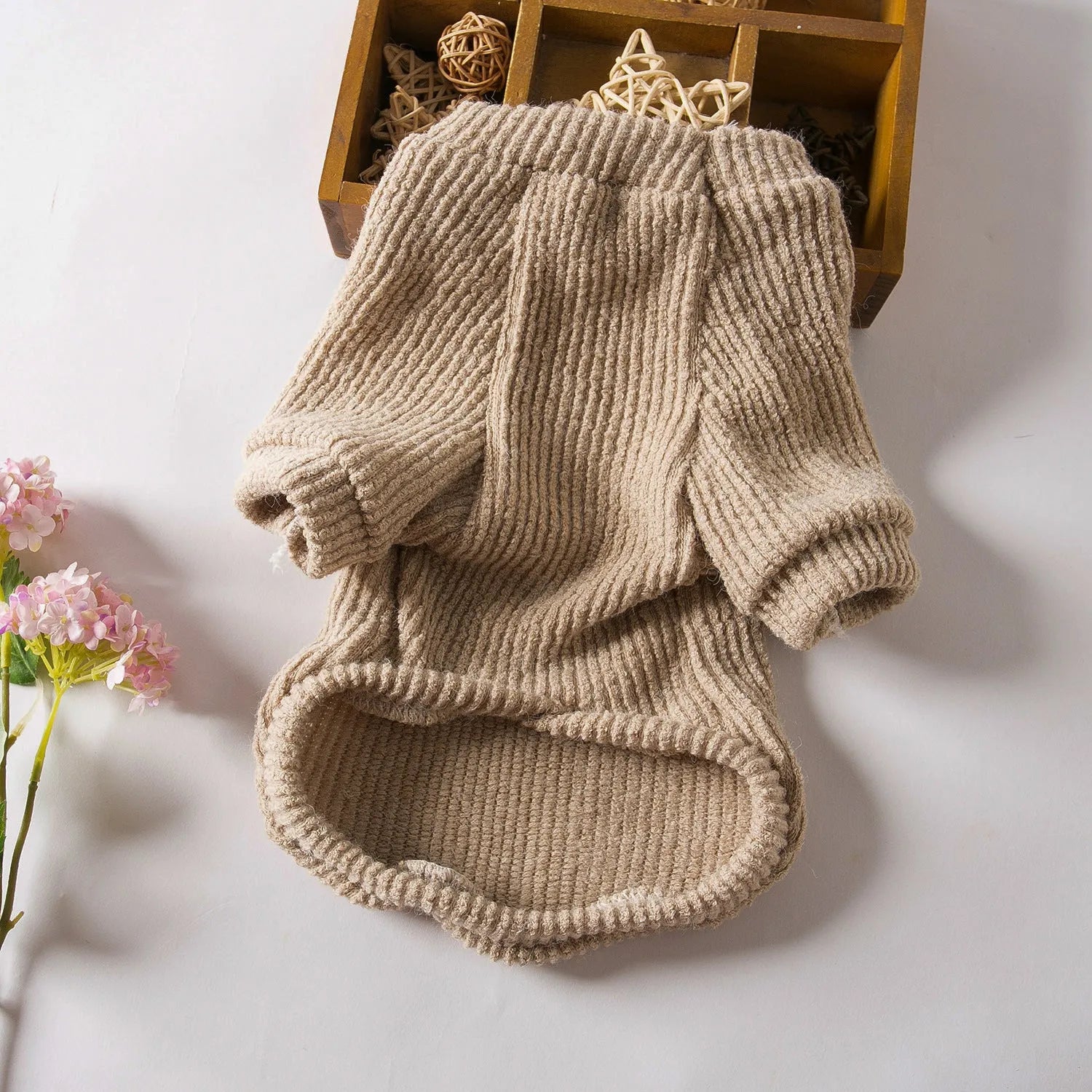 A brown knitted pullover sweater for a small dog on a mannequin.