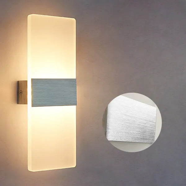 Modern acrylic LED wall lamp in silver finish showing warm light illumination