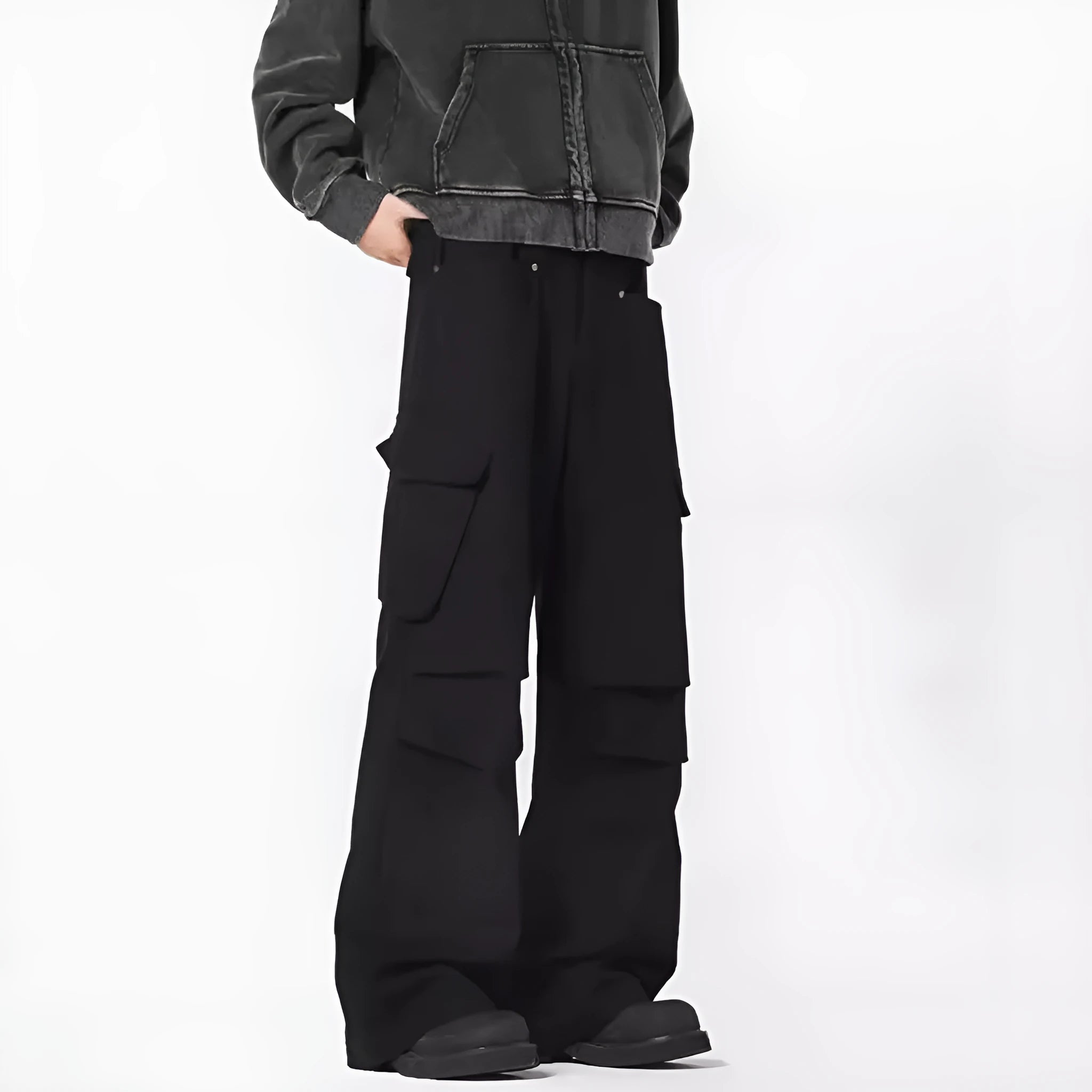 Men's black high-waisted straight-leg trousers with a button fly front, laid flat on a grey background.