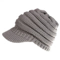 Women's knitted acrylic beanie hat designed for wearing with a ponytail or bun.