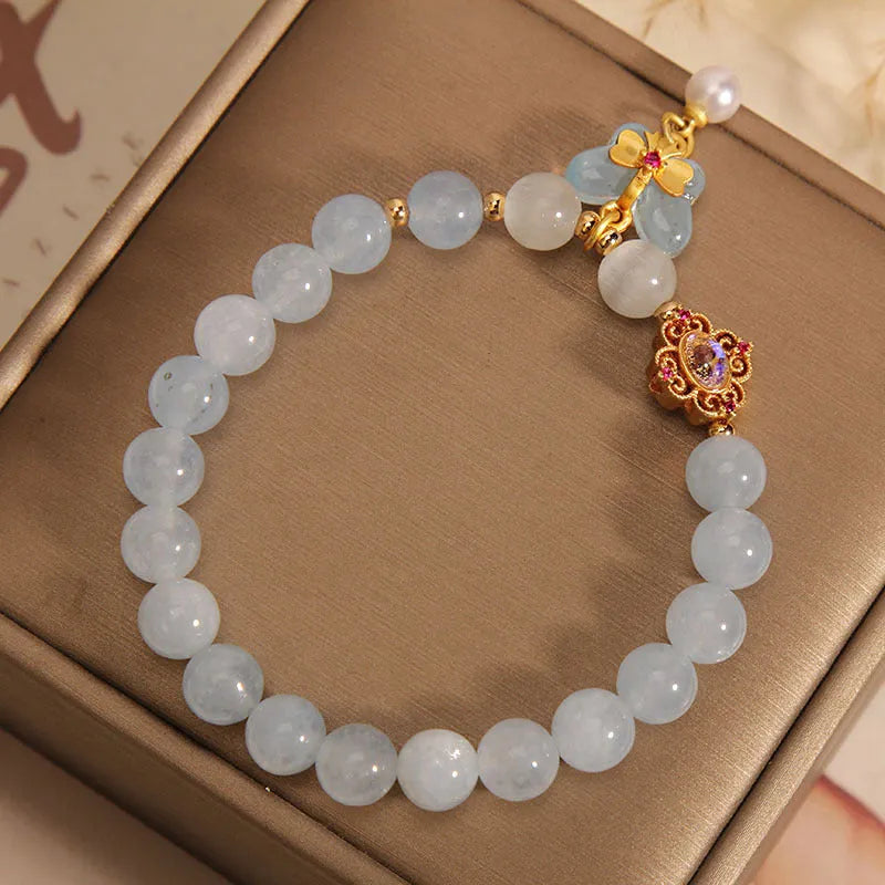 Aquamarine crystal butterfly pendant bracelet for women with rhinestone accents on a white background.
