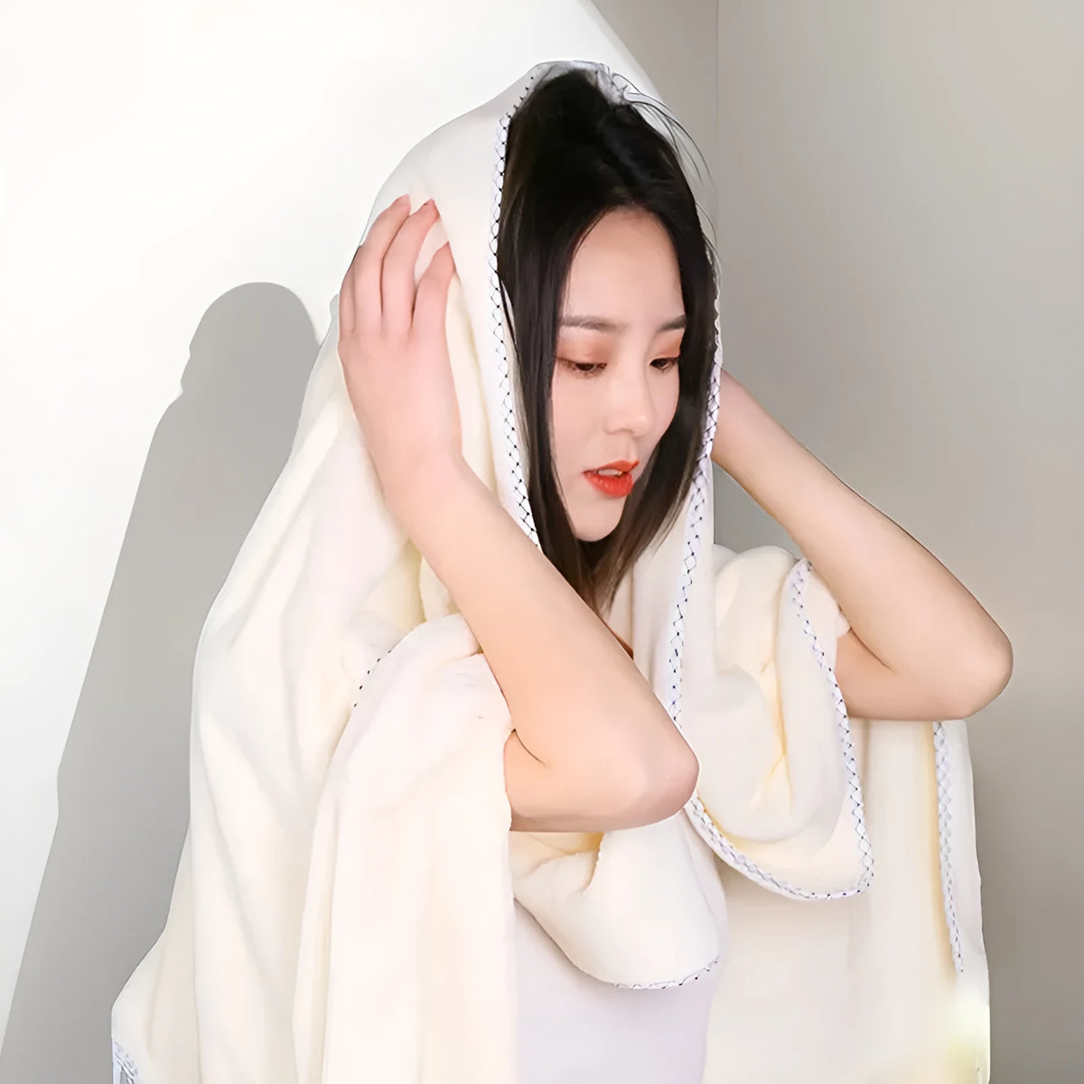 Three-piece coral fleece towel set in vanilla colour with one bath towel and two hand towels on a white background