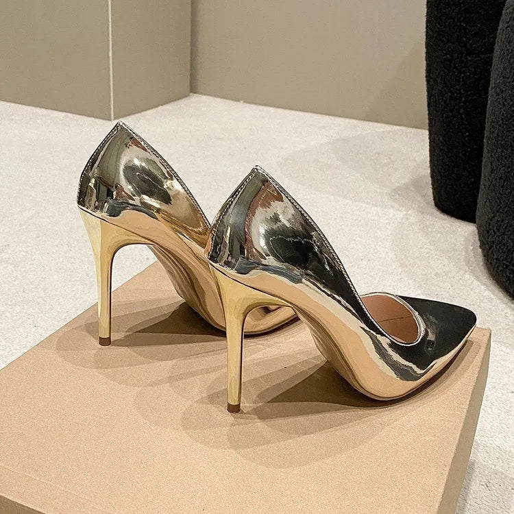 Gold pointed toe slip-on stiletto heel shoe on a white background.