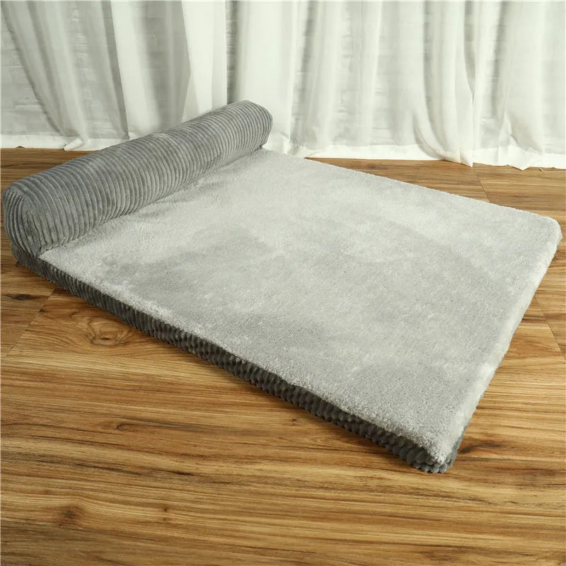 A large grey corduroy dog sofa bed with bilateral sides and a non-slip base on a wooden floor.