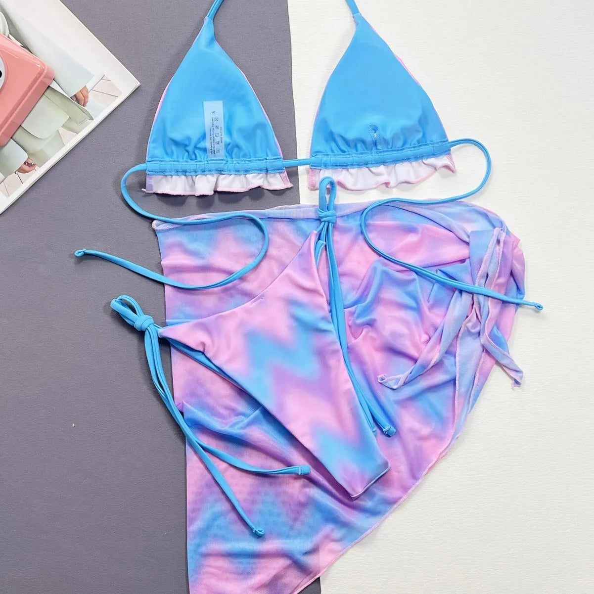 Women's tie-dye bikini swimsuit set with a skirt, bra, and matching briefs.