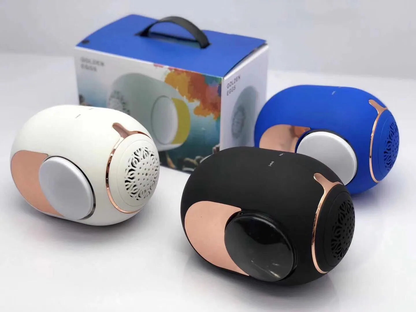 Small golden egg-shaped wireless Bluetooth speaker in black, white, or blue colour with charging cable.