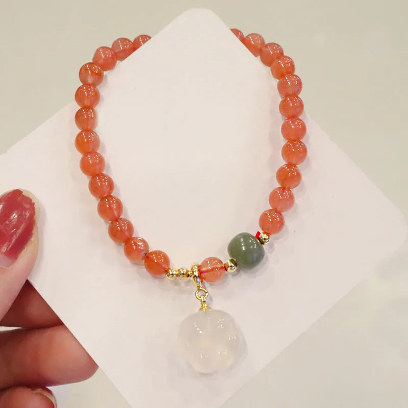 Natural red agate bracelet with jade accents showing 6mm beads and 8mm cat paw zodiac charms