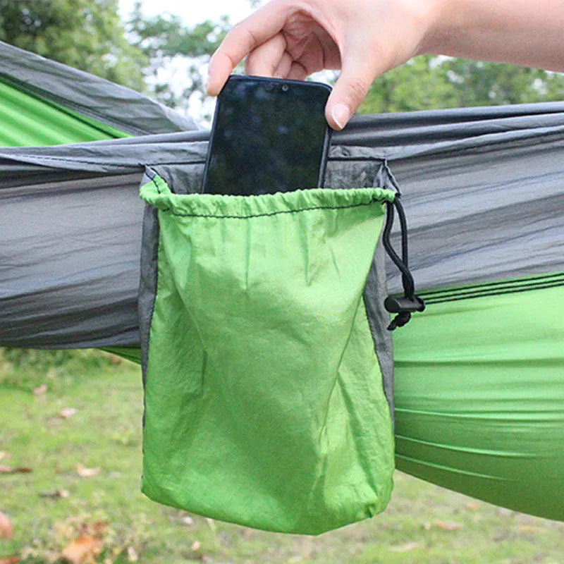 Blue nylon parachute cloth outdoor hammock hung between trees, showing its length and width.