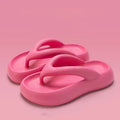A pair of solid colour thick-soled EVA flip-flops with a bow detail on the strap.