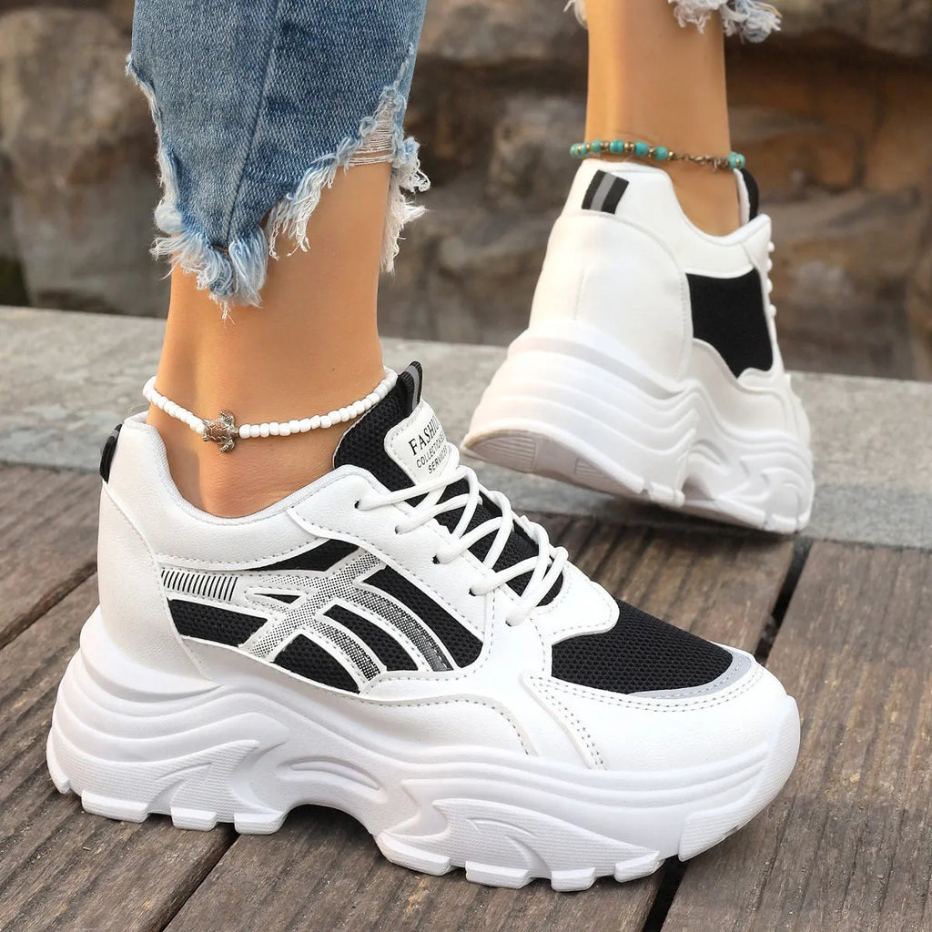 Women's platform wedge sneakers in black or white with mesh lining, rubber sole, front lace-up, round toe, and sewing thread detail.