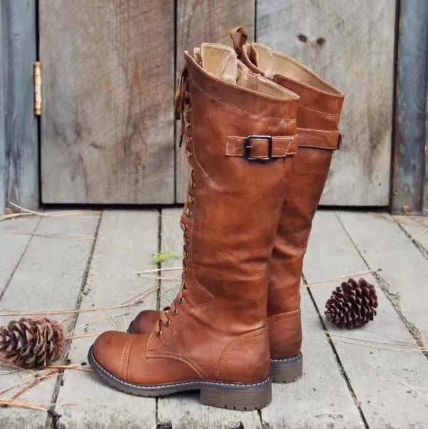 Women's black high-leg boots with a round toe and a low chunky rubber heel on a white background.