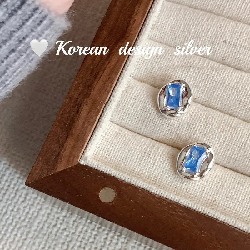 S925 sterling silver earrings with geometric heart-wrapped design and oval blue diamond elements