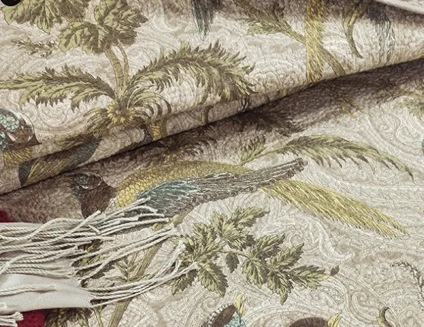 Blue American floral and bird pattern quilted cotton bedspread laid flat on a bed.
